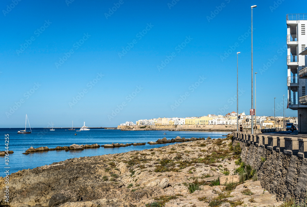 The rocky coastline and a view of the old town of Gallipoli from Lungomare Galilei, in Salento, Puglia region, Southern Italy, The rocky coastline and a view of the old town of Gallipoli from Lungomare Galilei, in Salento, Puglia region, Southern Italy,