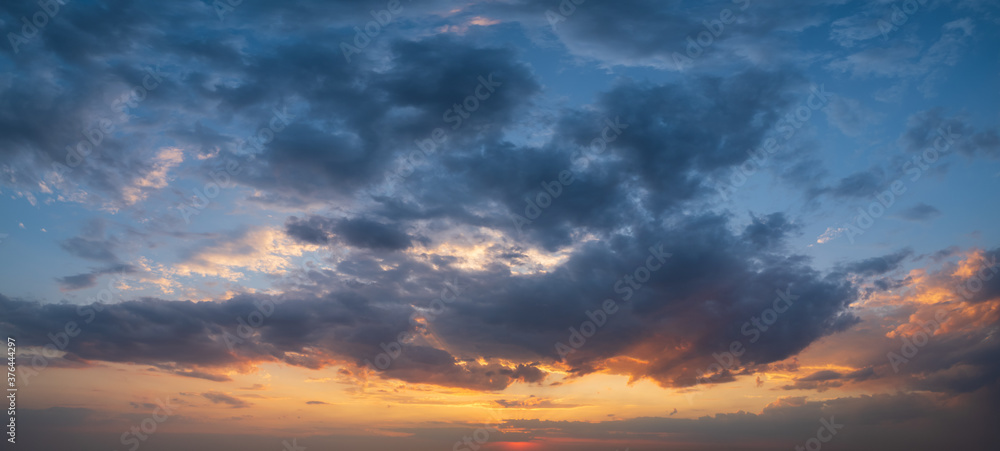 Summer sunset sky panorama with fleece colorful clouds. Evening dusk good weather natural background.