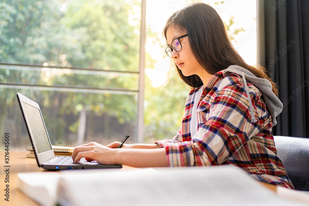Young Asian female student working and studying from home during the city lockdown due to the spreading of corona virus Young Asian female student working and studying from home during the city lockdown due to the spreading of corona virus