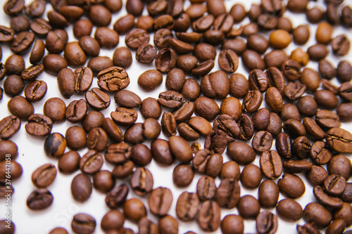 Coffee beans are scattered on a white background. Roasted coffee beans. Background.