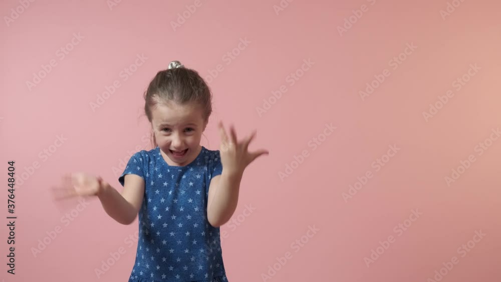 Beautiful cute brunette girl get angry and swears. Blue dress with polka dots. The girl has long hair. Pink background. Beautiful cute brunette girl get angry and swears. Blue dress with polka dots. The girl has long hair. Pink background.