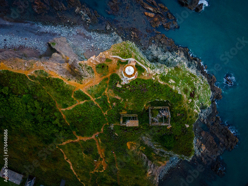 Above. Rudny lighthouse at Cape Briner in the village of Smychka (Rudnaya Pristan), Primorsky Territory. The beautiful Rudny lighthouse stands on a sheer cliff against the backdrop of a bright dawn photo