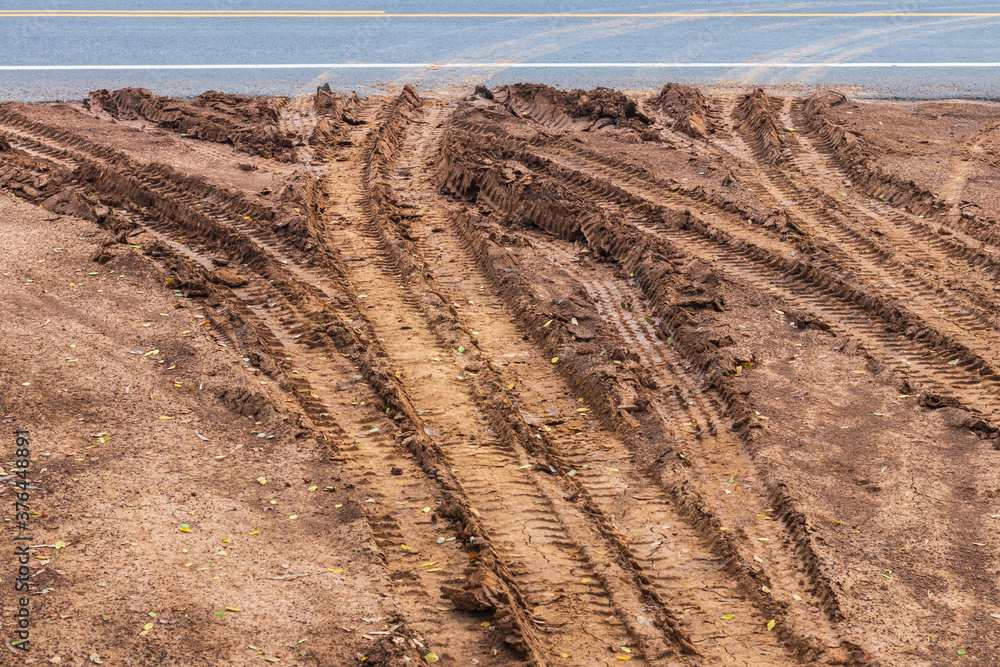 Muddy surface, dirt soil with wheel traces to paved roads. Muddy surface, dirt soil with wheel traces to paved roads.