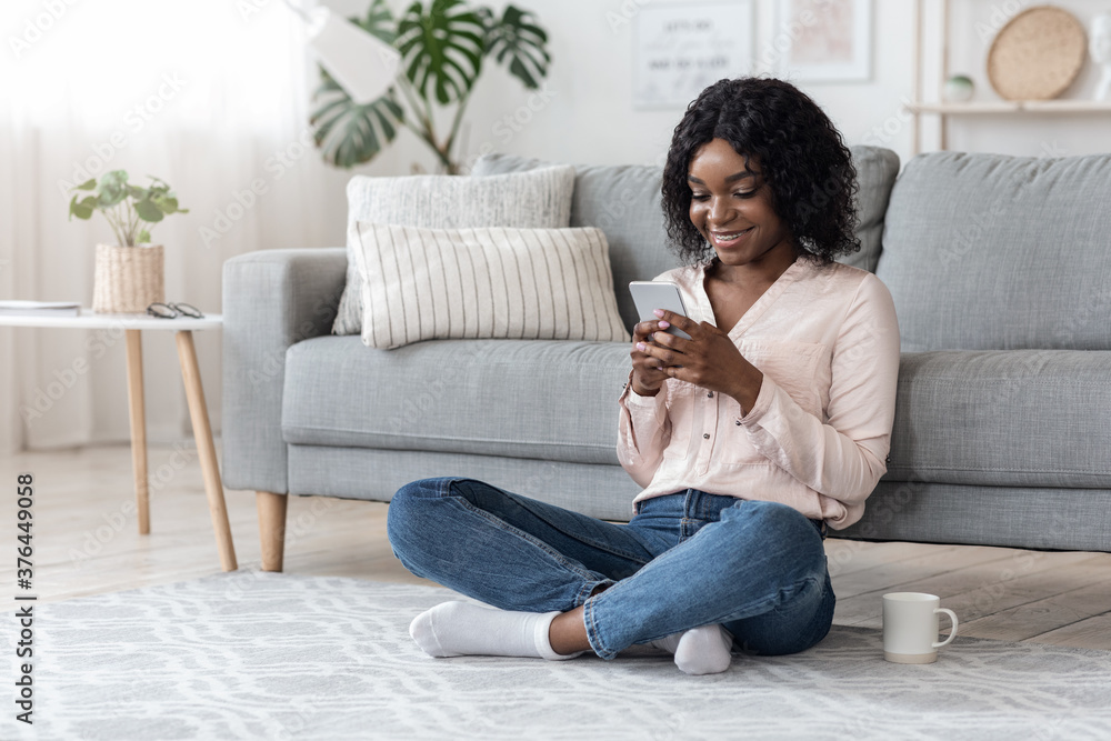 African Woman Browsing Social Media On Smartphone And Drinking Coffee At Home African Woman Browsing Social Media On Smartphone And Drinking Coffee At Home