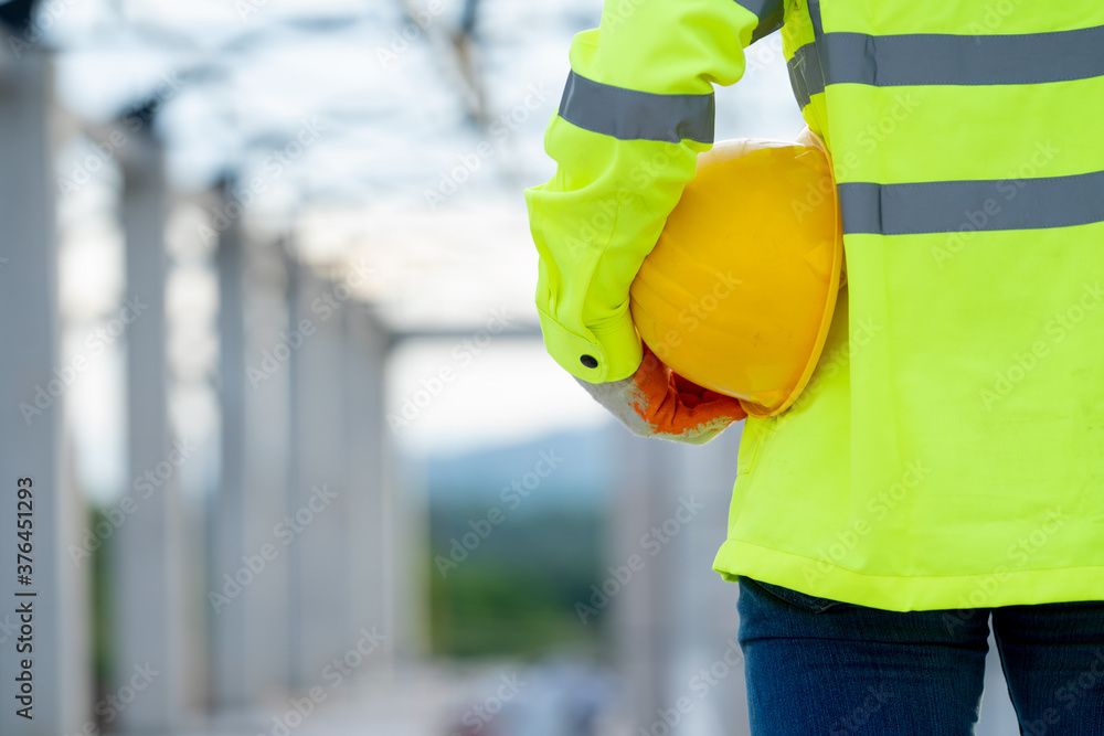 Engineer holding safety helmet at work on construction site. Engineer holding safety helmet at work on construction site.