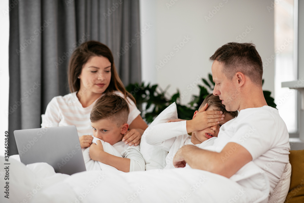 Beautiful parents with kids enjoying at home. Young family watching movie on lap top.. Beautiful parents with kids enjoying at home. Young family watching movie on lap top..