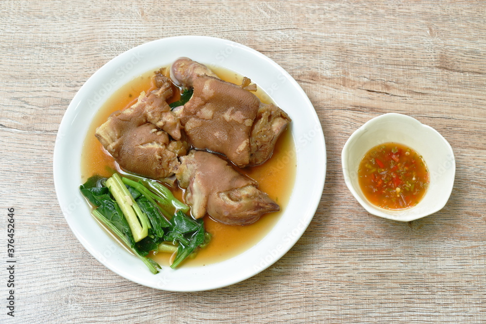 boiled slice pork leg and foot with Chinese kale in black herb soup on plate boiled slice pork leg and foot with Chinese kale in black herb soup on plate