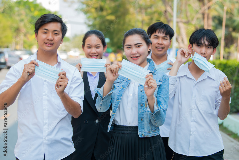 Group of Asian Businesspeople holding protective mask on the street. Protection covid19, against flu, pollution, contagious diseases. Group of Asian Businesspeople holding protective mask on the street. Protection covid19, against flu, pollution, contagious diseases.