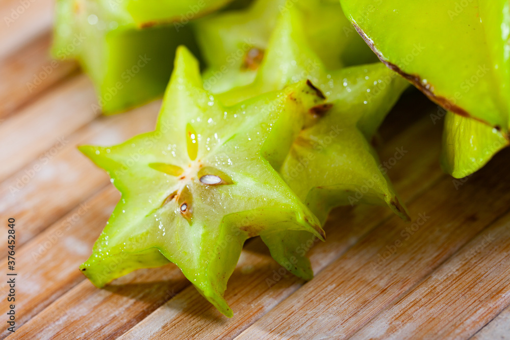 Fototapeta premium Carambola fruit on wooden table closeup. Vitamin fruits