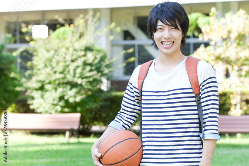 バスケットボールを持って微笑む男子大学生 photo