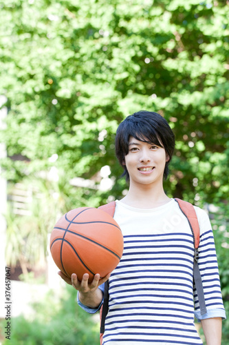 バスケットボールを持って微笑む男子大学生