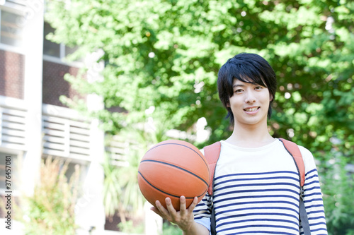 バスケットボールを持って微笑む男子大学生