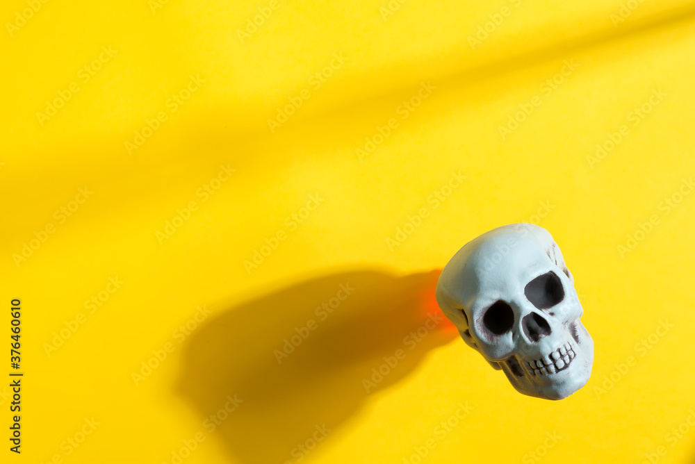 Human skull on a yellow background with shadow. Human skull on a yellow background with shadow.