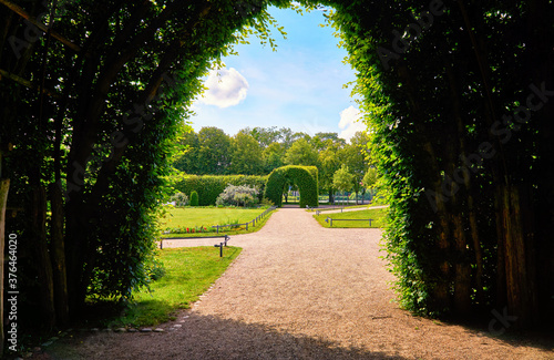 View through the green pergola into the palace gardens of Schwerin with a blue sky.