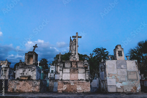 Old graveyard tombs with corsses and angel statue at the cemetery 'Cementerio General' in Merida, Yucatan, Mexico photo