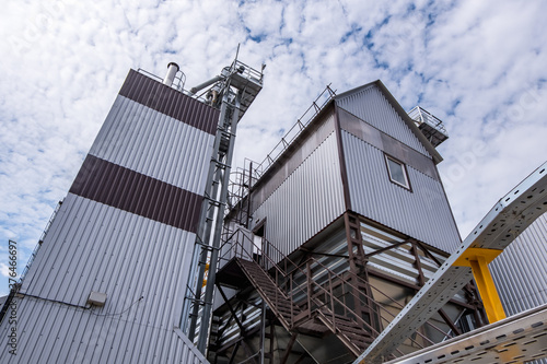 Modern Granary elevator. Silver silos on agro-processing and manufacturing plant for processing drying cleaning and storage of agricultural products, flour, cereals and grain. © hiv360