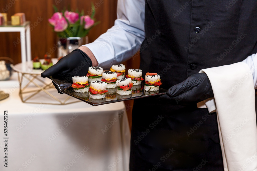 Catering, waiter carries snacks on plates