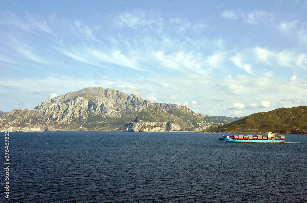 Blue container ship sailing near Spanish port, Ceuta. 