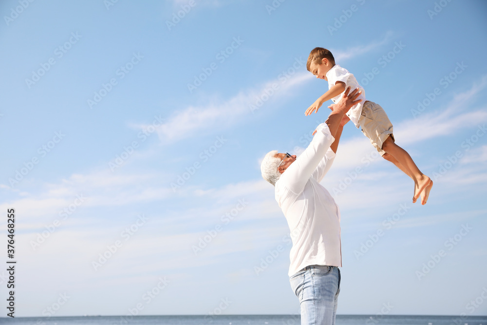 Cute little boy with grandfather having fun near sea Cute little boy with grandfather having fun near sea