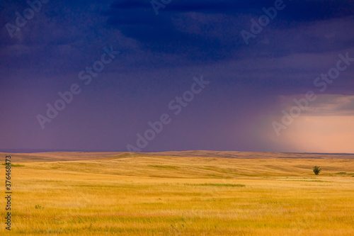 Rolling plains against a dark stormy sky in the Badlands, South Dakota