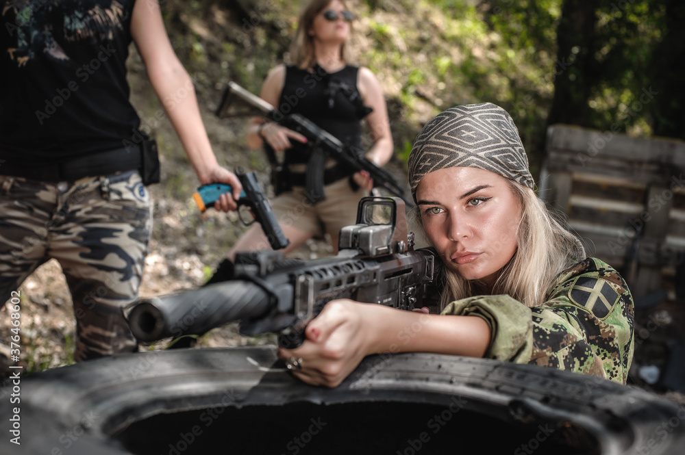 Combat team squad of attractive female military soldier have war training. Woman with weapon. Special forces. Outdoor shooting range