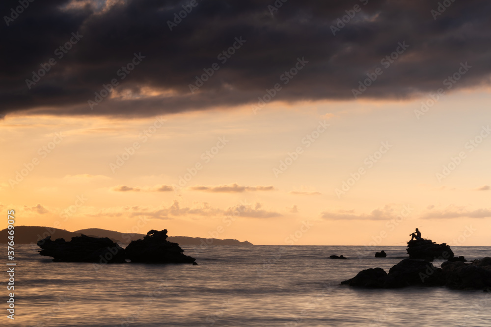 Rocks in the Mediterranean Sea backlit by the sunset