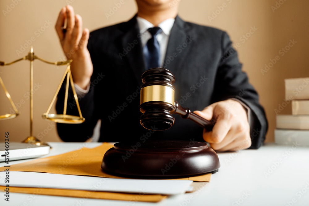 Business and lawyers discussing contract papers with brass scale on desk in office. Law, legal services, advice, justice and law concept picture with film grain effect Business and lawyers discussing contract papers with brass scale on desk in office. Law, legal services, advice, justice and law concept picture with film grain effect