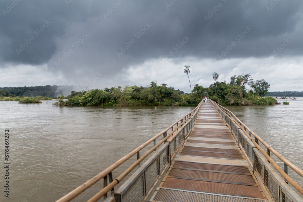 Walkways with people at the iguazu falls a cloudy and gray day