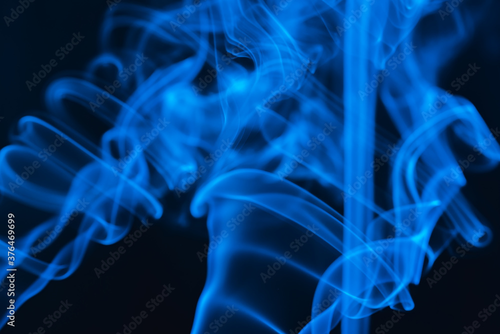 Fototapeta premium Blue abstract shaped smoke against black background. Abstract background