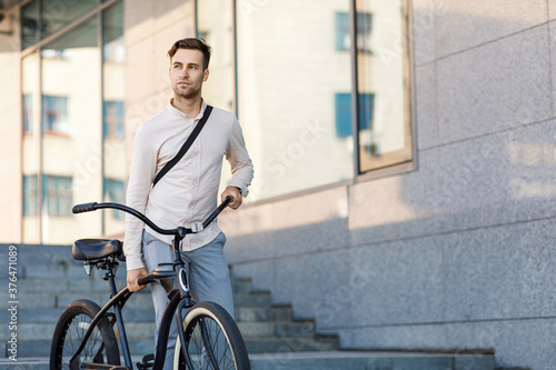 Convenient way to travel. Businessman in suit going to work by bike