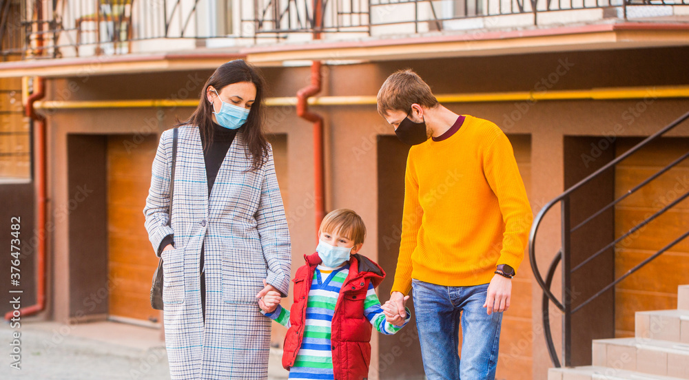 Parents and kid wearing a surgical mask. Air pollution concept. Prevention coronavirus. Coronavirus quarantine. Family going walk. Coronavirus, illness, infection, quarantine, medical masks Parents and kid wearing a surgical mask. Air pollution concept. Prevention coronavirus. Coronavirus quarantine. Family going walk. Coronavirus, illness, infection, quarantine, medical masks