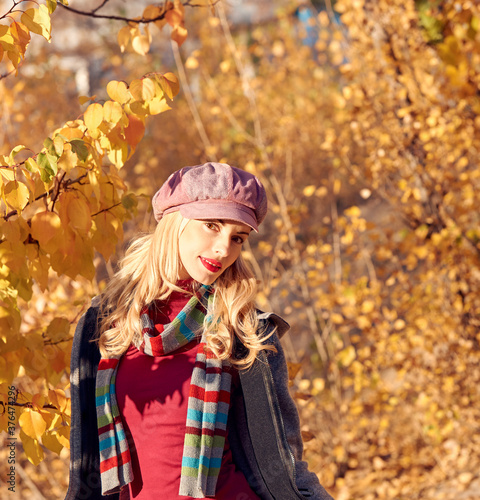 Autumn fashion outdoor. Young Beautiful happy woman relax at fall park  enjoy nature. Joyful blonde Model girl smiling have a good time  fashionable stylish autumnal portrait  falltime