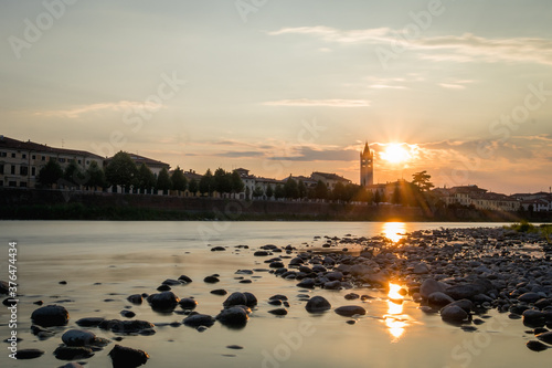 View of Basilica di San Zeno Maggiore in Verona in sunset looking above the Adige river with reflection on the water. Romantic picuture of a church in verona. photo