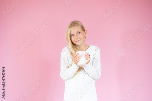 Smiling beautiful girl with a cup on pink background © Danko