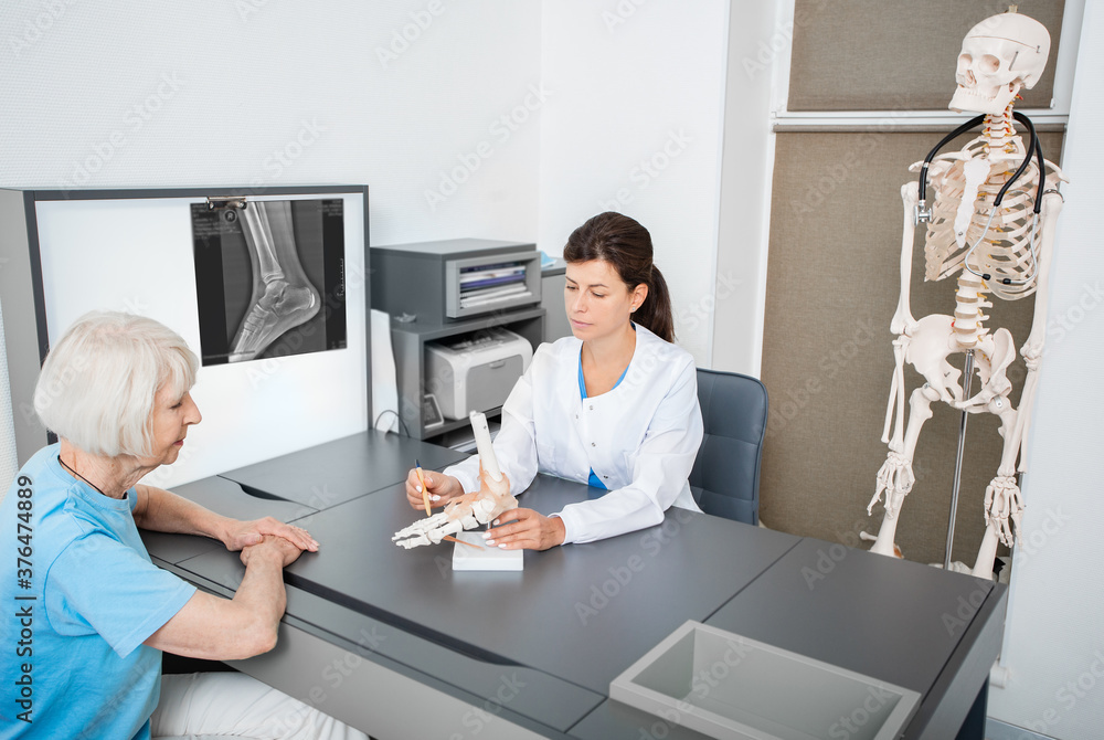 Obraz premium Rheumatologist and senior patient, consultation. Ankle and leg injury. Diagnostics and treatment of arthritis