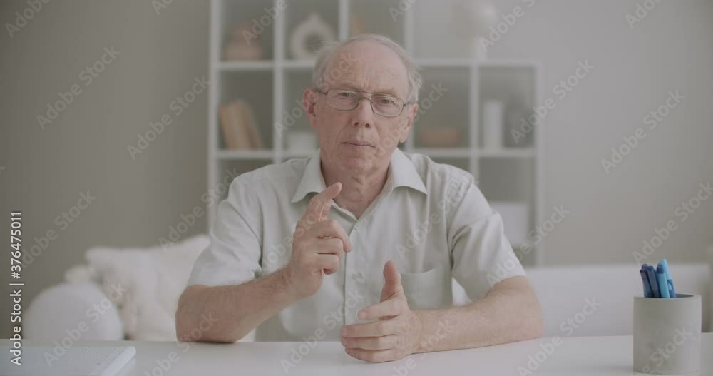 elderly blogger is talking and looking at camera, portrait of man at home, online communication and video chat elderly blogger is talking and looking at camera, portrait of man at home, online communication and video chat