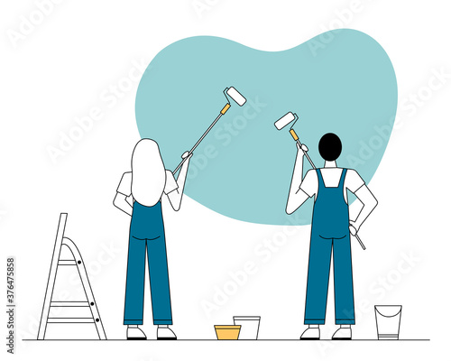 A man and a woman in overalls paint the wall with rollers. There is a stepladder nearby.