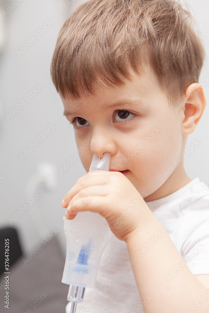 The boy makes inhalations. Treatment at home. Disease prevention The boy makes inhalations. Treatment at home. Disease prevention