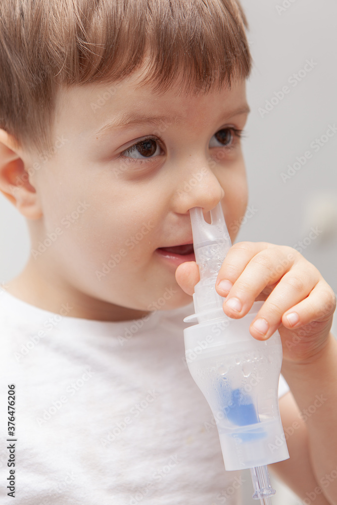 The boy makes inhalations. Treatment at home. Disease prevention The boy makes inhalations. Treatment at home. Disease prevention