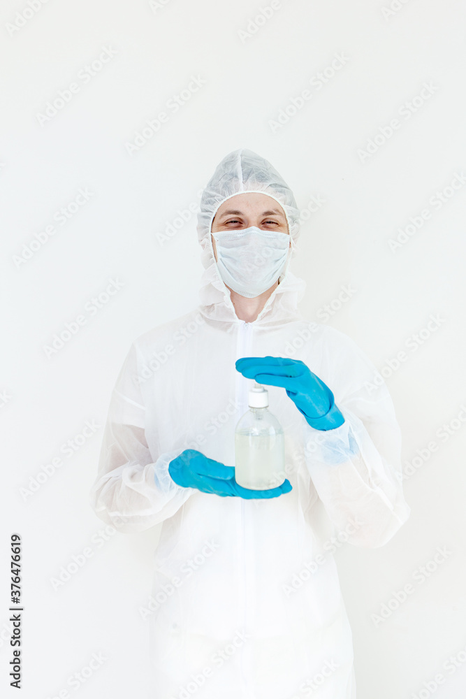 A man in a protective suit holds an antibacterial antiseptic gel for hand disinfection. Health care prevention during an outbreak of the flu virus and a coronavirus epidemic A man in a protective suit holds an antibacterial antiseptic gel for hand disinfection. Health care prevention during an outbreak of the flu virus and a coronavirus epidemic