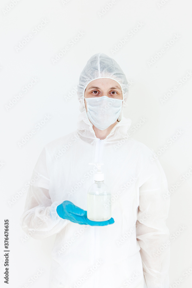 A man in a protective suit holds an antibacterial antiseptic gel for hand disinfection. Health care prevention during an outbreak of the flu virus and a coronavirus epidemic A man in a protective suit holds an antibacterial antiseptic gel for hand disinfection. Health care prevention during an outbreak of the flu virus and a coronavirus epidemic
