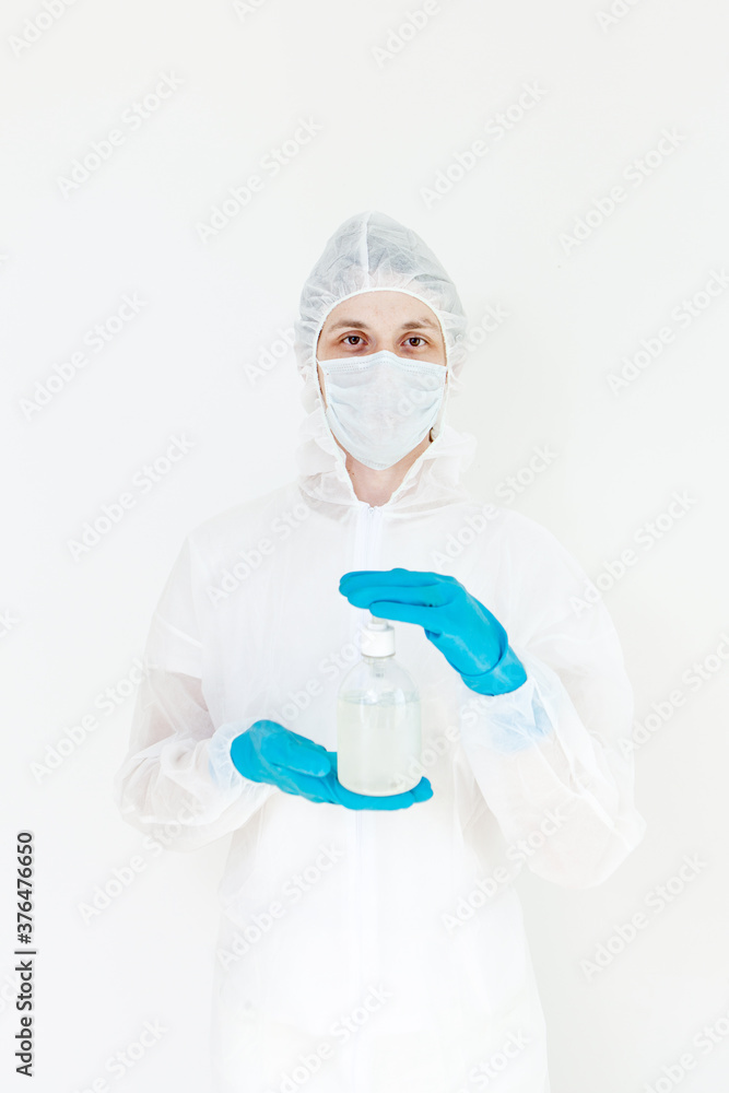 A man in a protective suit holds an antibacterial antiseptic gel for hand disinfection. Health care prevention during an outbreak of the flu virus and a coronavirus epidemic