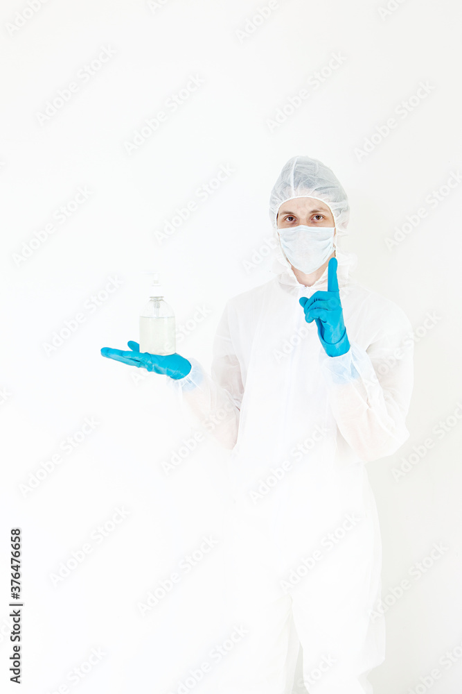 A man in a protective suit holds an antibacterial antiseptic gel for hand disinfection. Health care prevention during an outbreak of the flu virus and a coronavirus epidemic A man in a protective suit holds an antibacterial antiseptic gel for hand disinfection. Health care prevention during an outbreak of the flu virus and a coronavirus epidemic