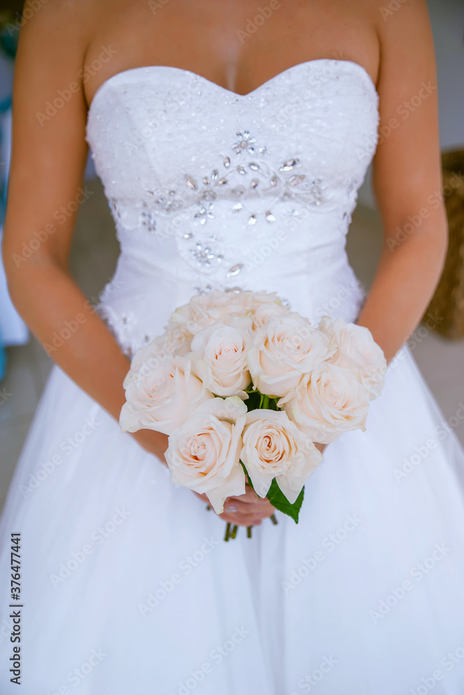 Beautiful, sophisticated bride wearing a ballgown style dress and holding a round pink roses bouquet, delicate floral arrangement and symbolic accessory, a romantic way to express love and partnership Beautiful, sophisticated bride wearing a ballgown style dress and holding a round pink roses bouquet, delicate floral arrangement and symbolic accessory, a romantic way to express love and partnership