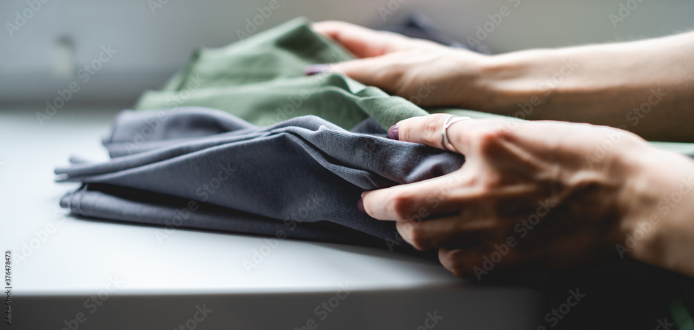Selective focus of artisan holding fabric on windowsill Selective focus of artisan holding fabric on windowsill