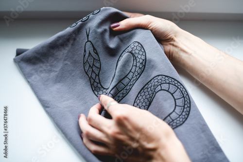 Fotografia Artisan touching print on cloth after screen printing in workshop