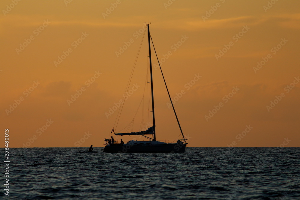 A sailboat on the sea at sunset