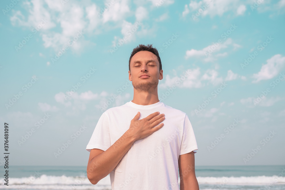 the guy sits on the seashore and meditates. the guy sits on the seashore and meditates.