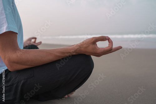 the guy sits on the seashore in the lotus position and meditates.