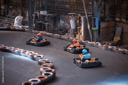 Three guys racing with go karts indoors